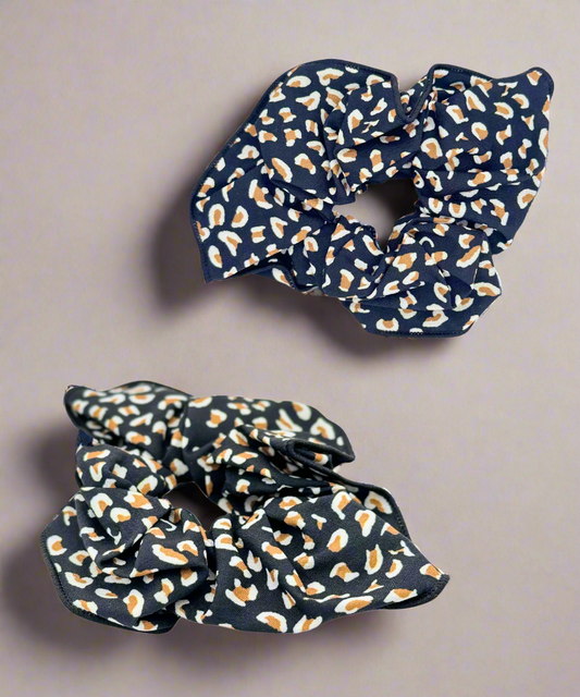 A stylish fabric scrunchie featuring a bold leopard print design, perfect for adding a trendy touch to any hairstyle.