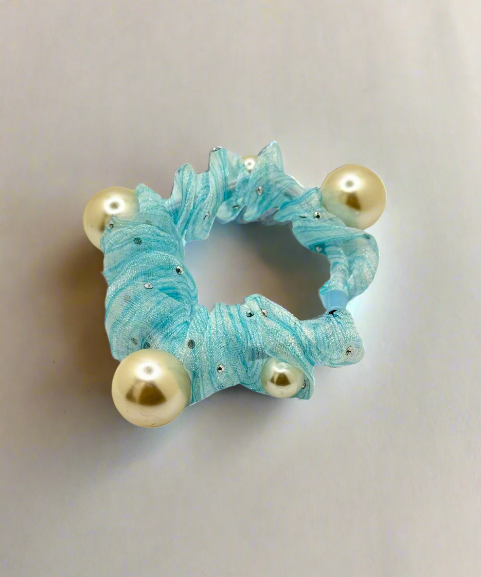 A mesh scrunchie with multiple pearl accents, featuring a delicate and stylish design for an elegant hair look.