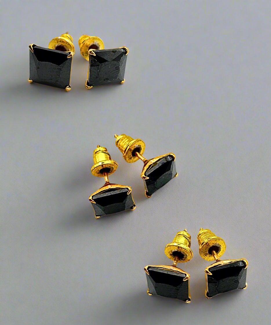 A pair of square-cut black stone stud earrings set in a gold-tone frame, offering a sleek and timeless look.