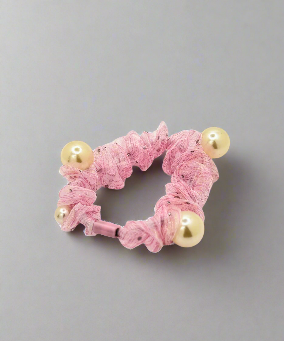 A mesh scrunchie with multiple pearl accents, featuring a delicate and stylish design for an elegant hair look.