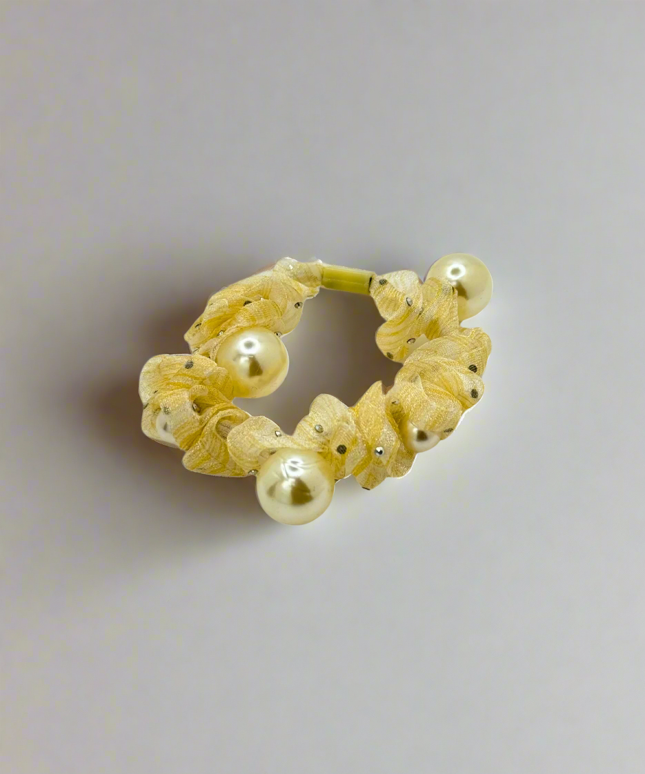 A mesh scrunchie with multiple pearl accents, featuring a delicate and stylish design for an elegant hair look.